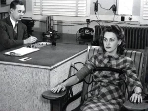 A vintage black-and-white image of a lady taking the polygraph exam
