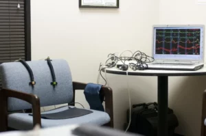 The polygraph test environment room (chair, computer, table, sensors, and devices).