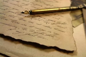 A letter including elegant handwriting and an ancient pen.