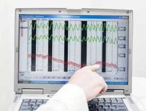 A hand pointing to a lie detector graph on a computer screen