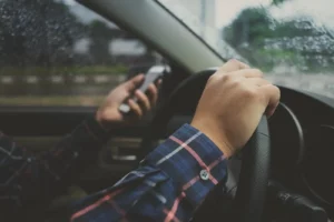 a detective using his phone while driving a vehicle