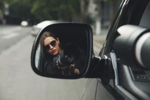 a female detective taking photos from a car