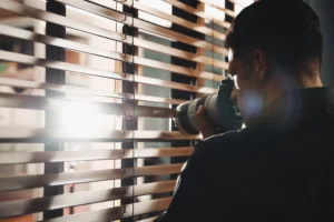 an investigator capturing images through a curtain