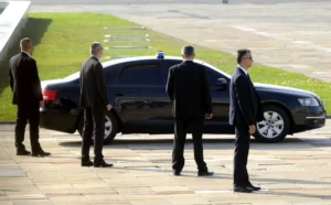 A vehicle is surrounded by 4 trained executive protection officers to create a secure space.