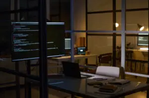 No people interior shot of modern office equipped with computers and laptops late in evening, copy space